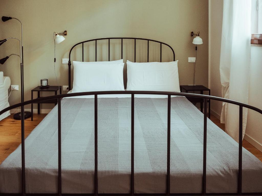 a bed with two white pillows and two lamps at BRE Apartments - Fresche Frasche in Vicenza