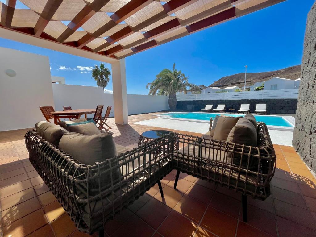 a patio with couches and a swimming pool at Villalia Isora in Playa Blanca