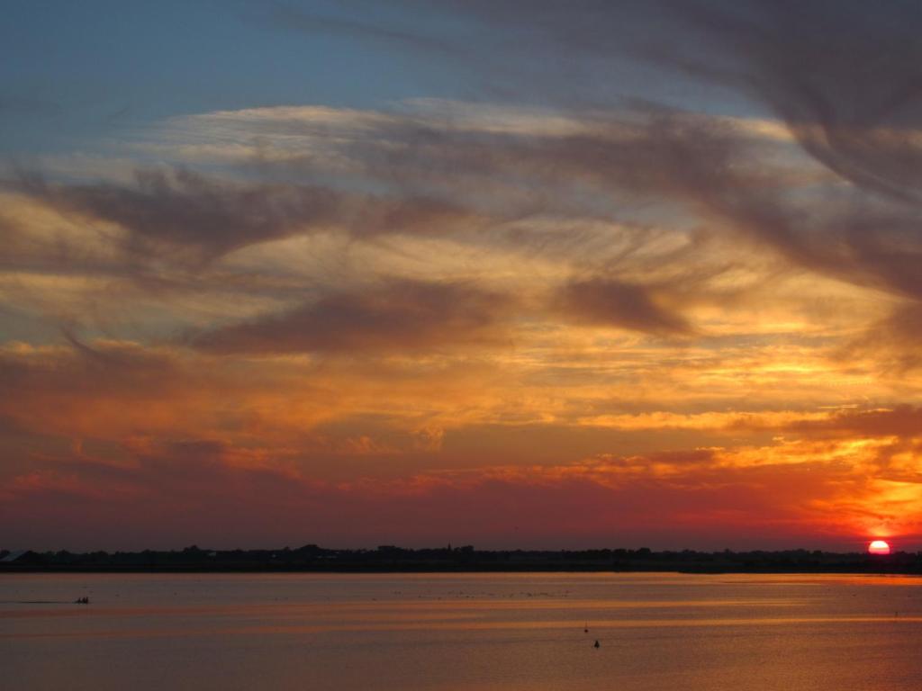 a sunset over a body of water at Fehmarn-OstseeferienHimmelskieker 173 in Burgtiefe auf Fehmarn 