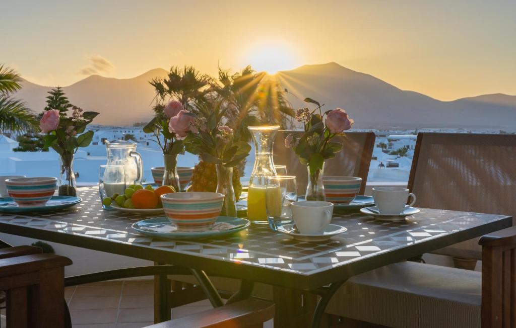 un tavolo con cibo e fiori in cima a un balcone di Villalia Maday a Playa Blanca