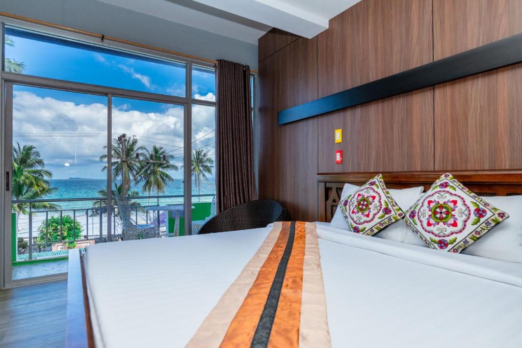 um quarto com uma cama e vista para o oceano em Talay Sai @ Thung Wua Laen em Pathiu