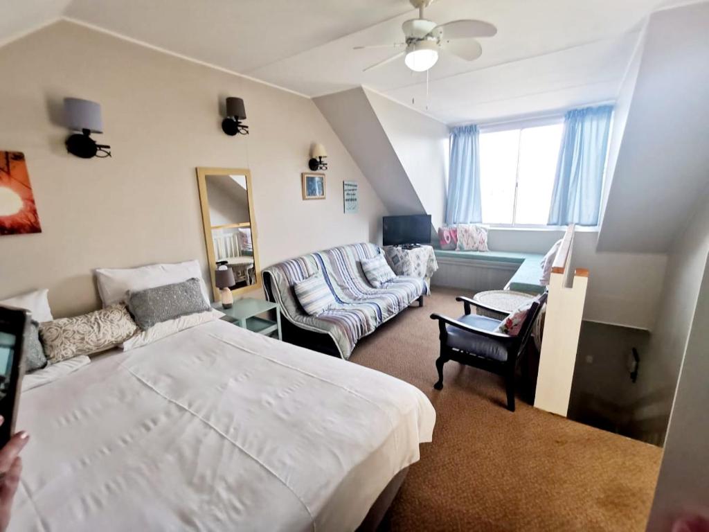 a bedroom with a bed and a living room at The Coelacanth Guest House And Beach Thyme Self Catering in Kiddʼs Beach