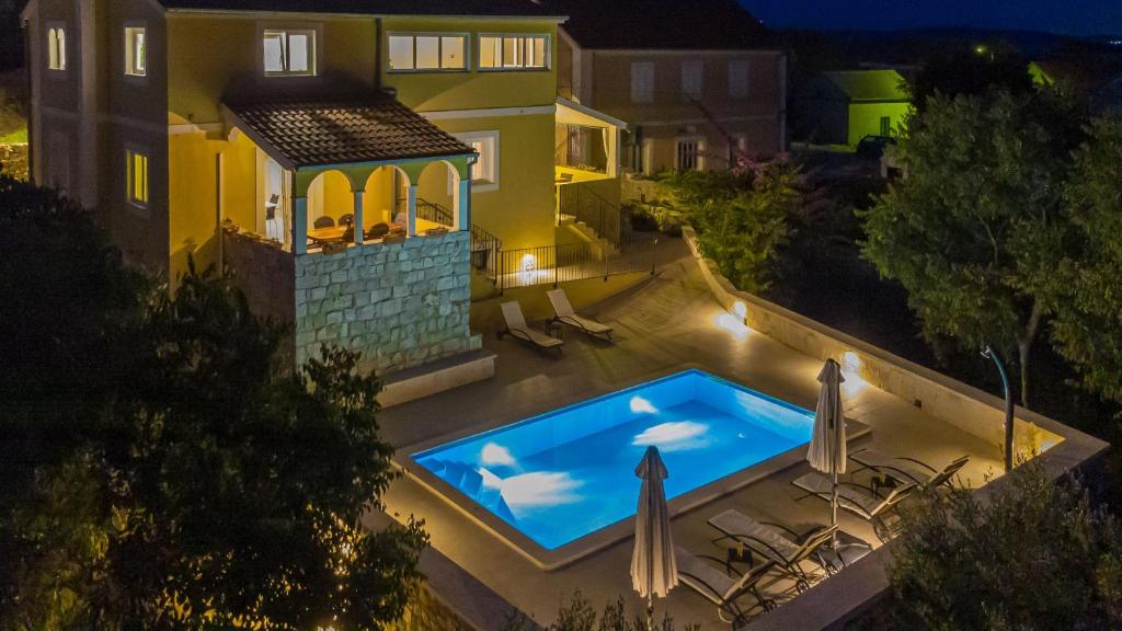 a swimming pool in the backyard of a house at night at Villa Sali in Sali