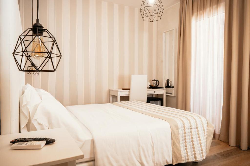 1 dormitorio con cama, mesa y ventana en Hotel Blue Marine, en Lignano Sabbiadoro