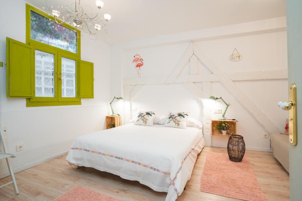 1 dormitorio con 1 cama blanca y armarios verdes en Apartamentos LÓRIEN Zarautz, en Zarautz
