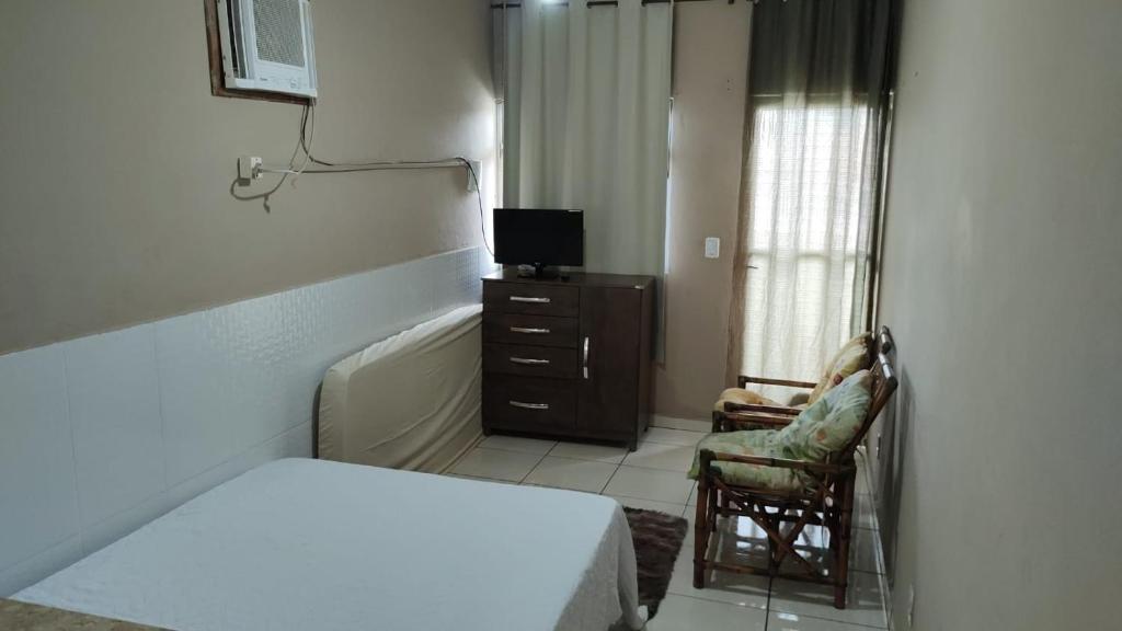 1 dormitorio pequeño con 1 cama y 1 silla en Loft, en Angra dos Reis