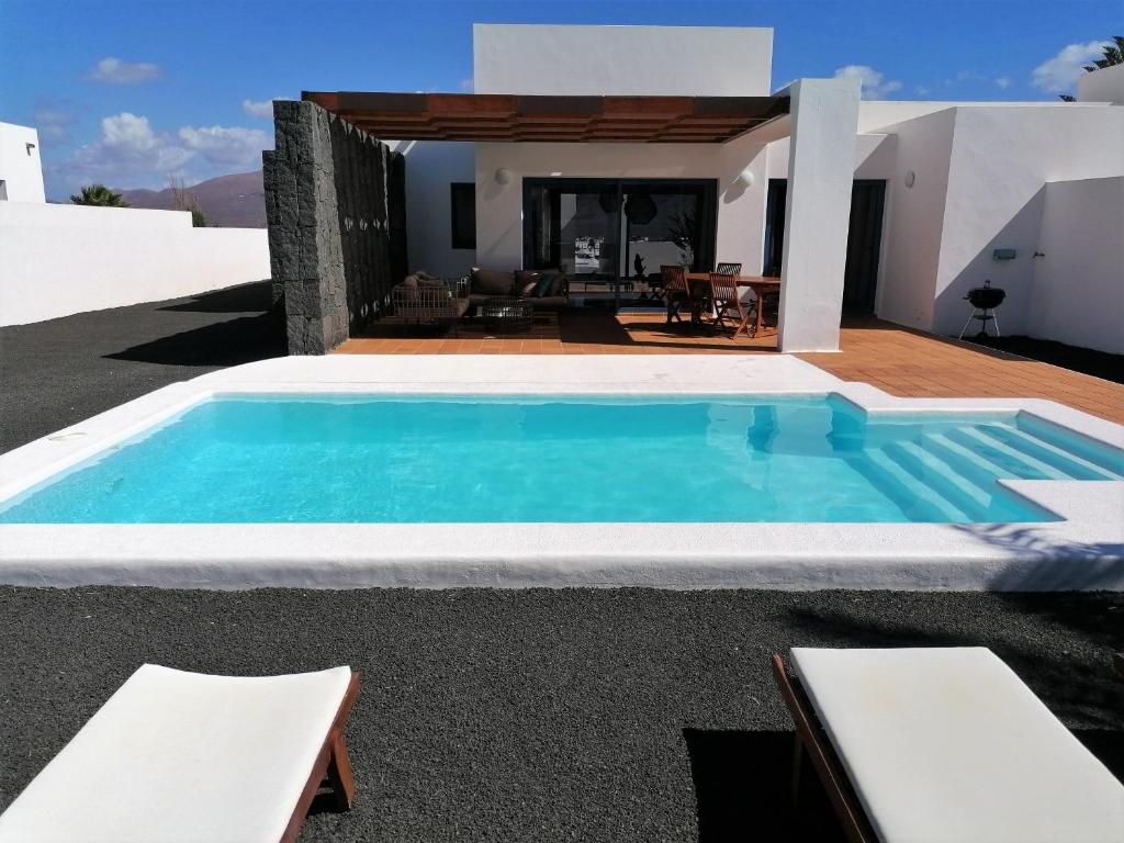 a villa with a swimming pool in front of a house at Villalia Zaida in Playa Blanca