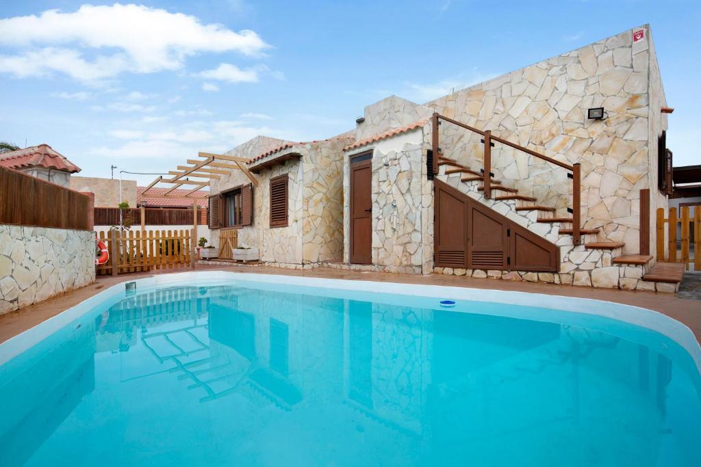 a villa with a swimming pool and a house at Las Casitas 28 in Corralejo