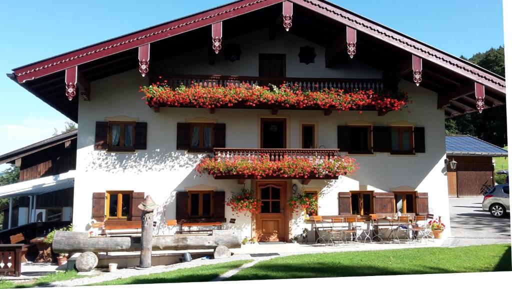 a white building with flowers on the balcony at Bojernhof in Ruhpolding