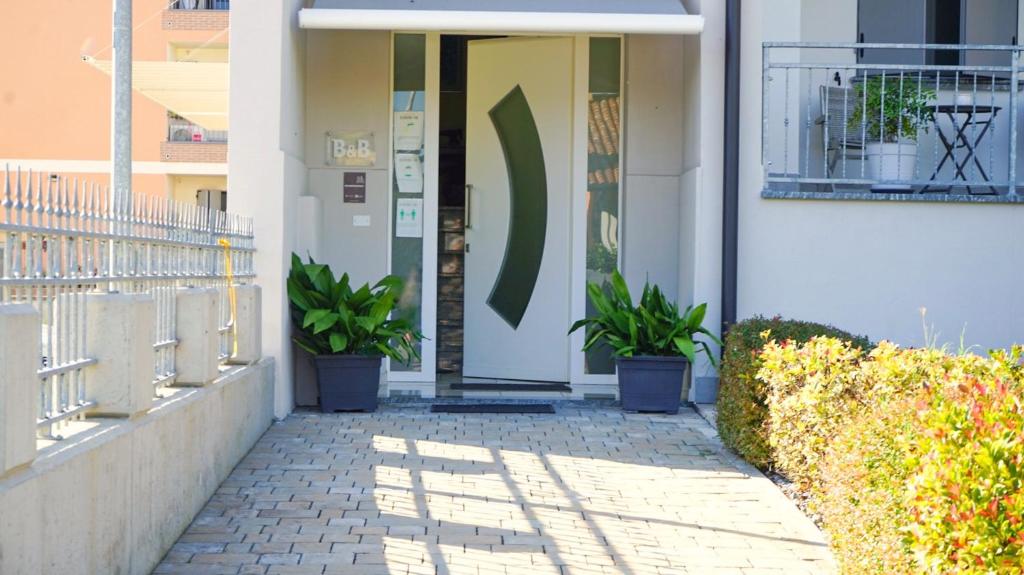 a front door of a building with potted plants at Bed & Breakfast La Pilona in Bagnolo San Vito