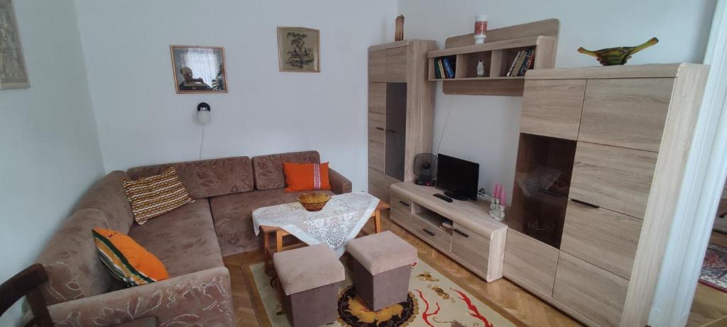 ein Wohnzimmer mit einem Sofa und einem Entertainment-Center in der Unterkunft Júlia Apartman. in Budapest
