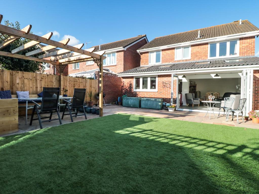 a backyard with a lawn with a table and chairs at Sandy Toes in Christchurch
