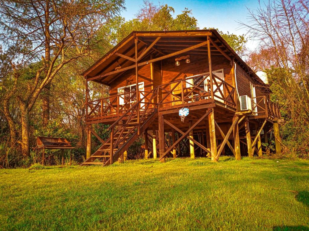 a large wooden house in a field of grass at Cabaña Ilusión - Complejo Marea in Tigre