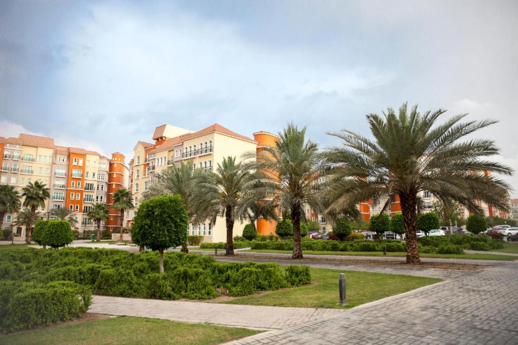 une rangée de palmiers devant un bâtiment dans l'établissement Expo Stay, à Dubaï