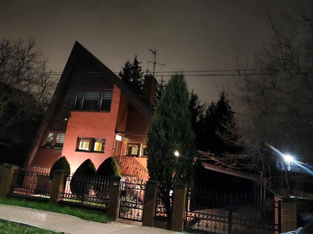 uma casa com uma cerca em frente à noite em Dom blisko centrum em Kielce