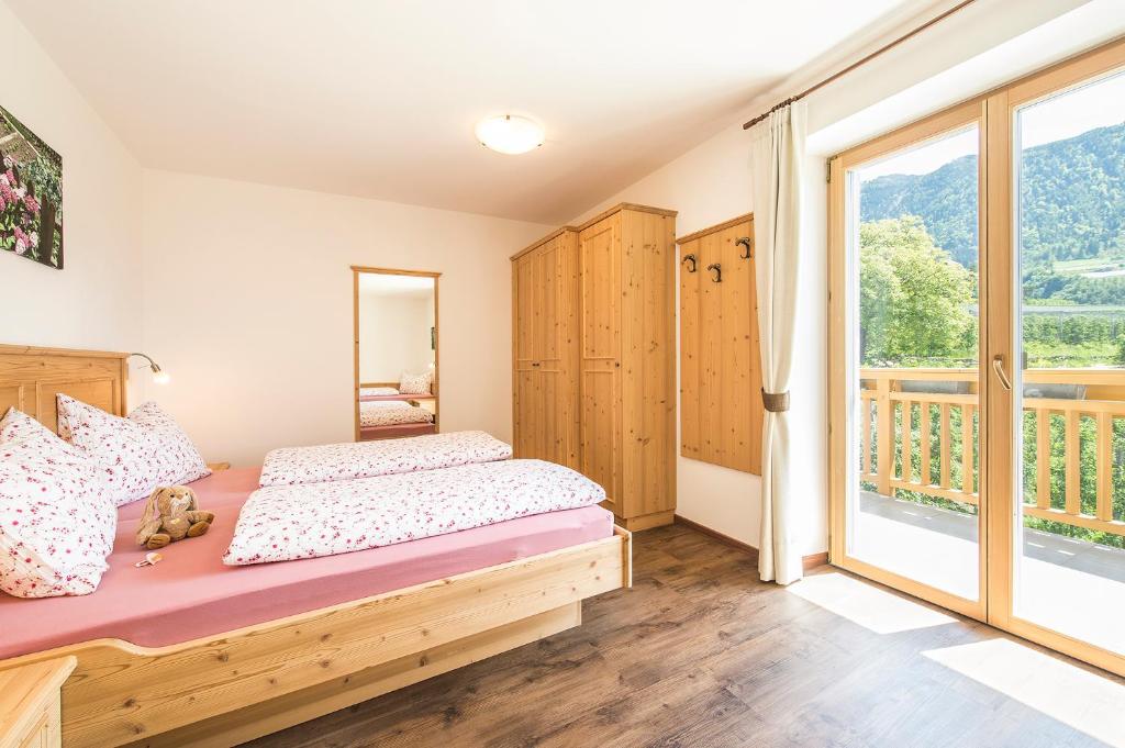 a bedroom with a bed and a large window at Gassbauerhof Ferienwohnung Ass in Schenna