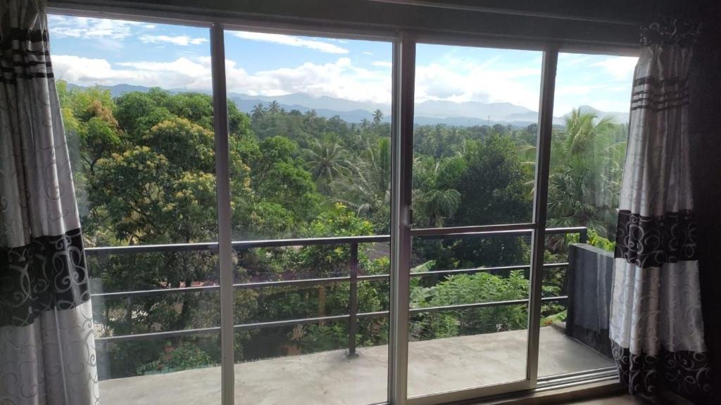 a window with a view of a forest at Kandy Penhouse in Kandy