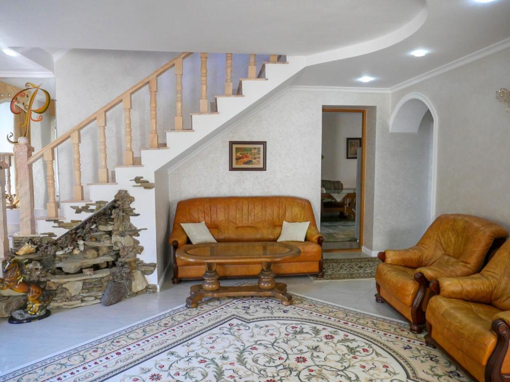 a living room with a couch and a staircase at Kiki's Villa in Chişinău