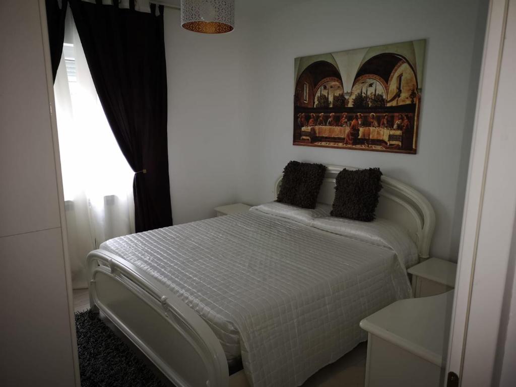 a bedroom with a white bed and a picture on the wall at Apartament Darius in Târgu Ocna