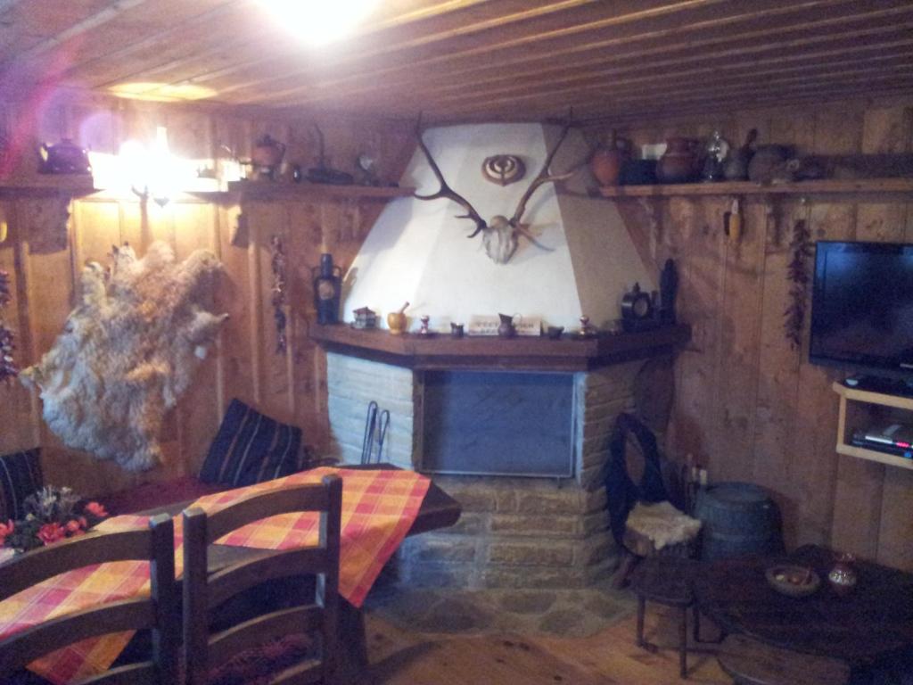 um quarto com lareira e um relógio na parede em кьща за гости Свети Никола em Zheravna