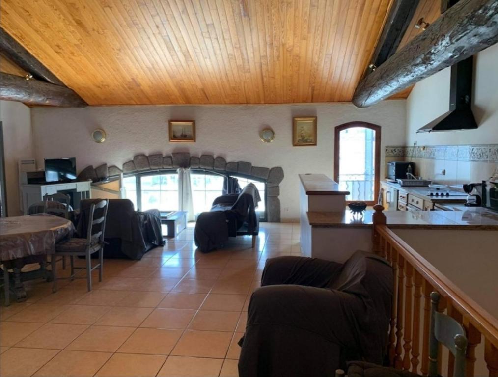 sala de estar con sofás, mesa y cocina en Appartement d'exception sur le port pittoresque de Marseillan en Marseillan