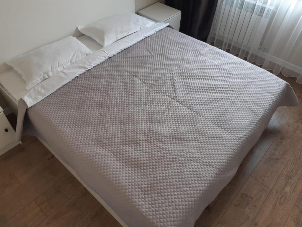 a white bed with white sheets and pillows on it at Квартира на речке Есентайка in Almaty