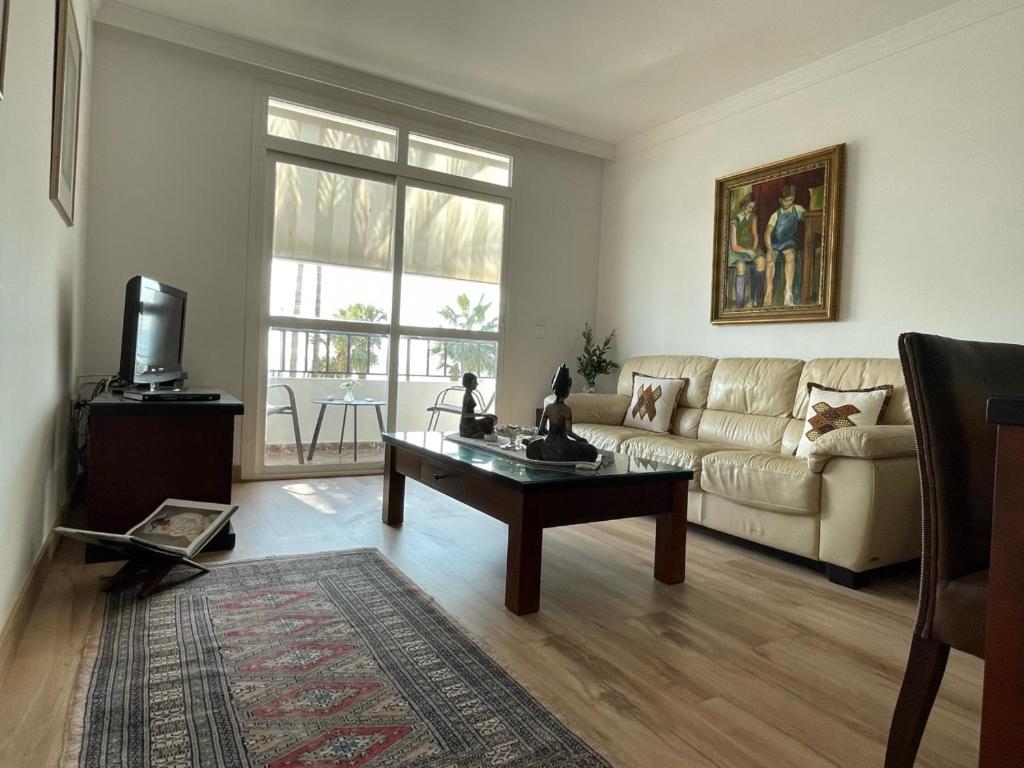 een woonkamer met een bank en een salontafel bij Apartamento frente a la playa Piso 2 in Estepona