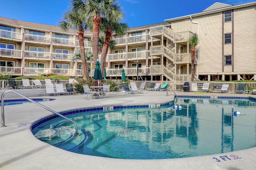 a swimming pool in front of a apartment building at Breakers At Hilton Head in Hilton Head Island