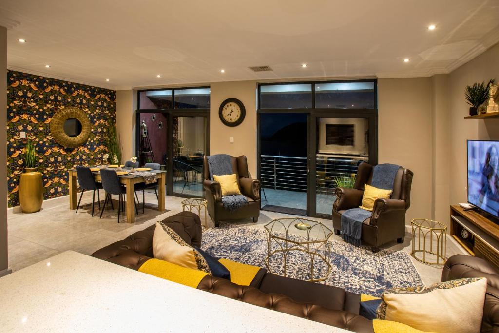 a living room with a couch and chairs and a table at Stay at The Point- Royal Relaxing Retreat in Durban