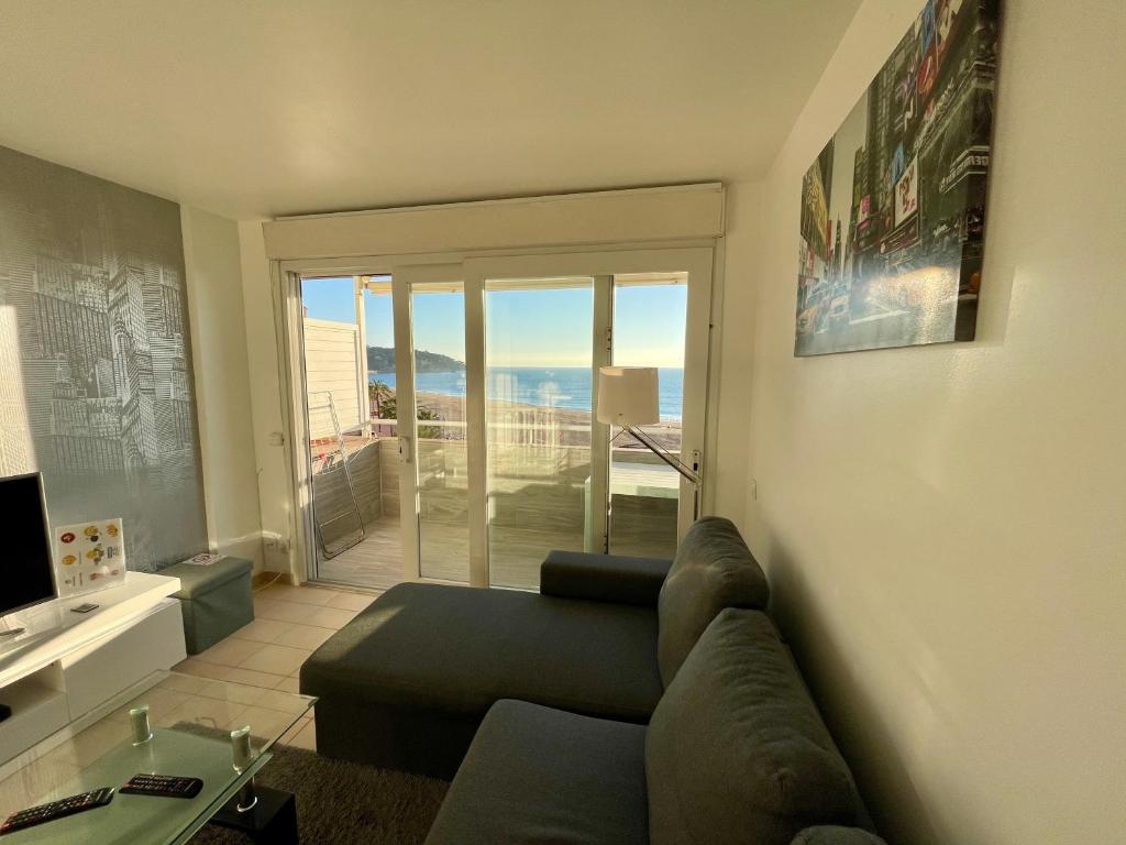 a living room with a couch and a view of the ocean at Apartments Paradise Lloret in Lloret de Mar