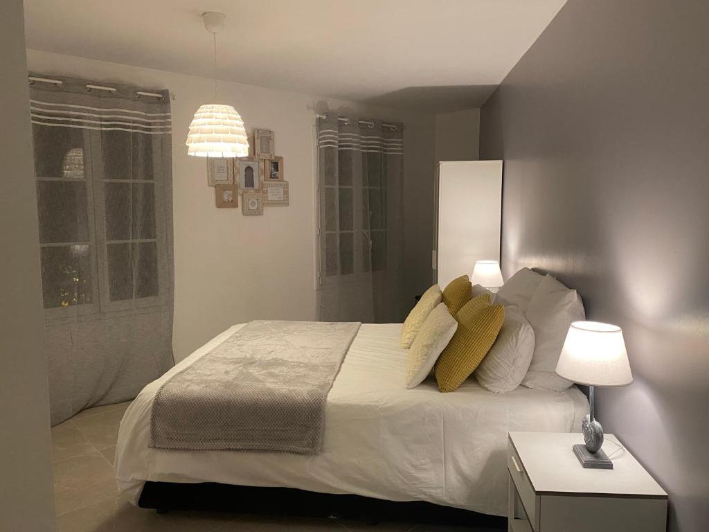 um quarto com uma grande cama branca com almofadas amarelas em Cosy By DREAM APARTMENTS em Serris
