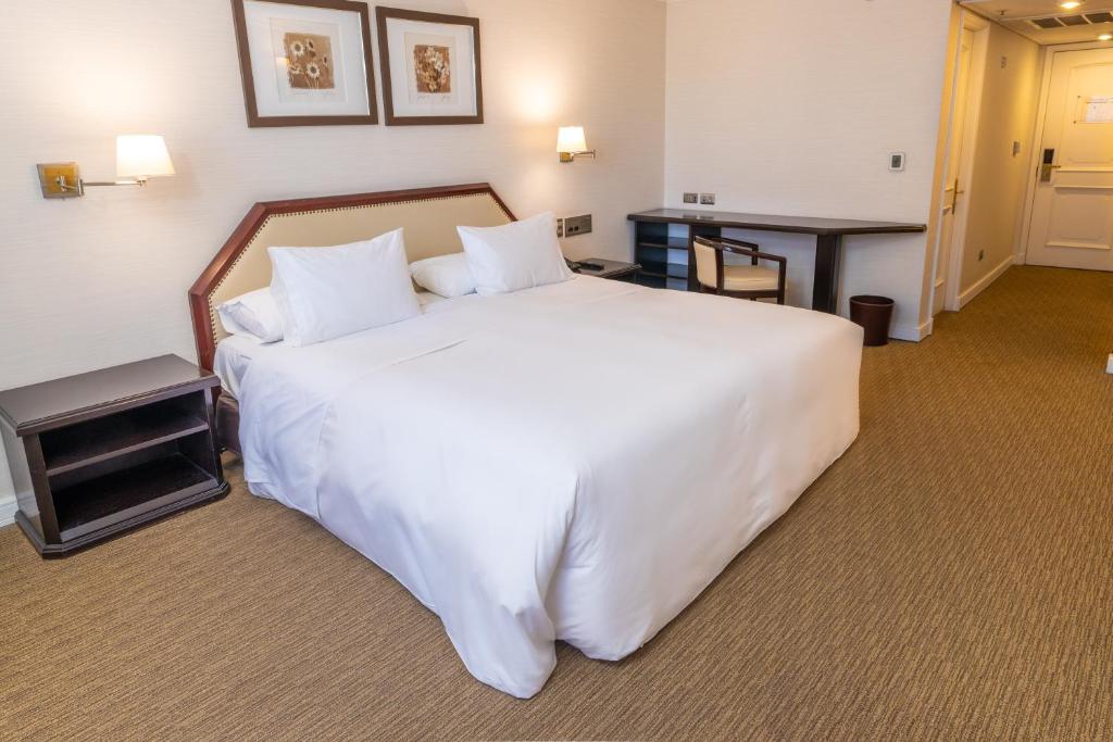 1 cama blanca grande en una habitación de hotel en Wyndham Garden Santiago Kennedy, en Santiago