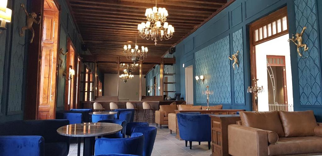 un restaurante con paredes azules, mesas y sillas en Hotel San Francisco Tlaxcala, en Tlaxcala de Xicohténcatl