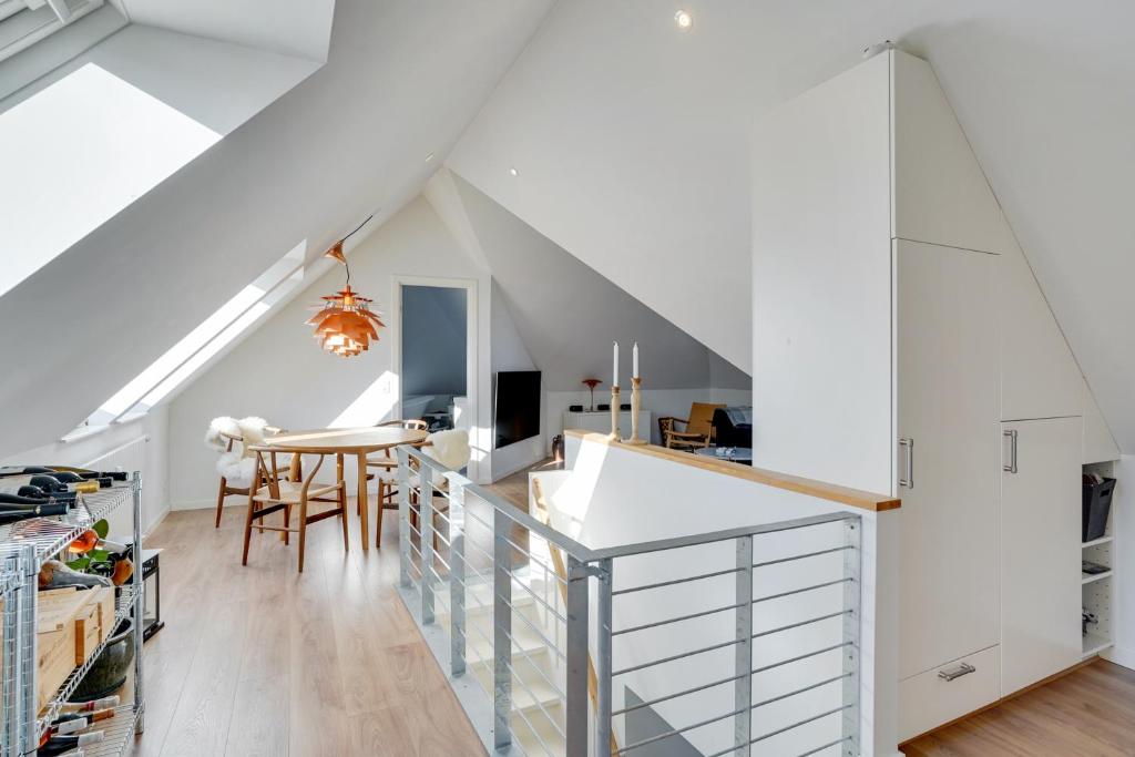 eine Küche im Dachgeschoss und ein Esszimmer mit weißen Wänden in der Unterkunft Bath tub penthouse in the city in Aalborg