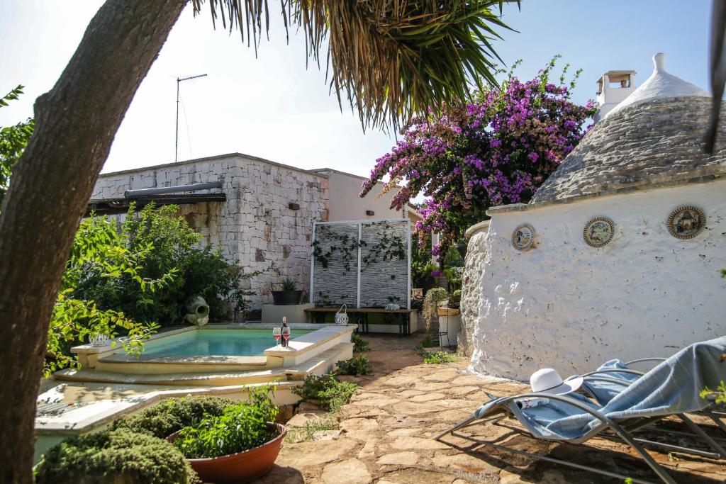 un patio trasero con piscina y una casa en Trullo Madia e Dimora Giorgio, en Ceglie Messapica