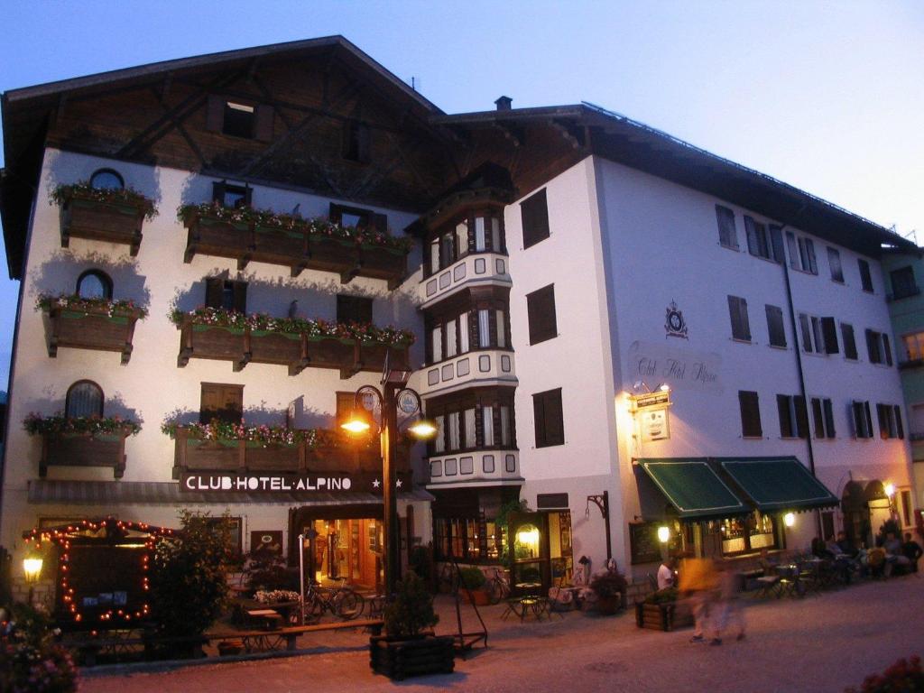 un gran edificio blanco con cajas de flores. en Club Hotel Alpino, en Folgaria