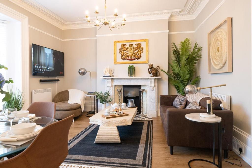 a living room with a couch and a fireplace at The Regal Apartment in Royal Tunbridge Wells