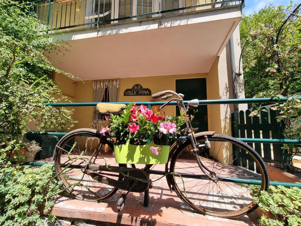 ein Fahrrad mit einem Korb voller Blumen in der Unterkunft Villa Pina in Laigueglia