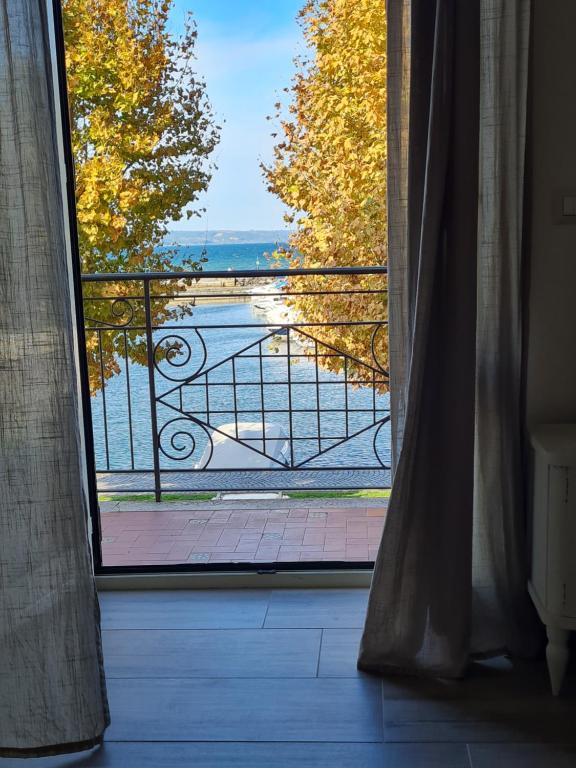 an open door to a balcony with a view of the water at La casetta del nonno in Capodimonte