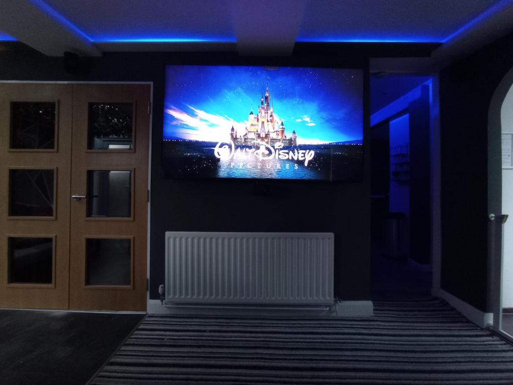 uma sala de estar com uma televisão na parede em Movie nights and Chill em Manchester