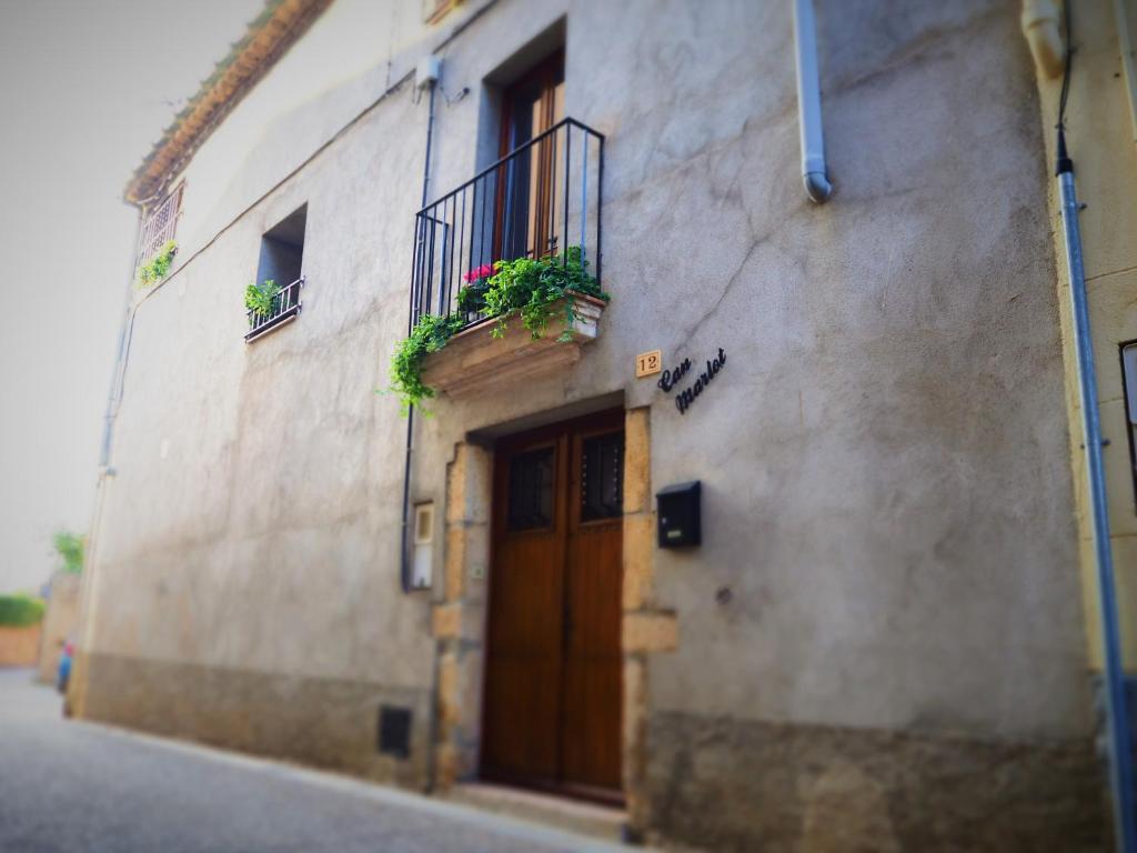 a building with a brown door and a balcony at Can Marlot in Navata