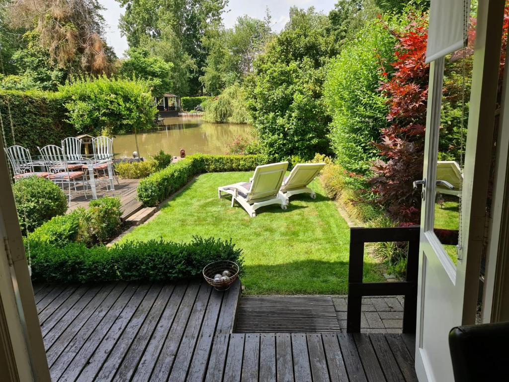 Elle offre une vue sur une cour avec des chaises et un jardin. dans l'établissement Rent & Relax: De steiger, à Geel