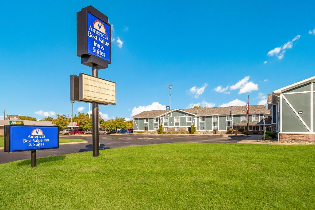 a sign in the grass in front of a building at Americas Best Value Inn & Suites-Birch Run in Birch Run