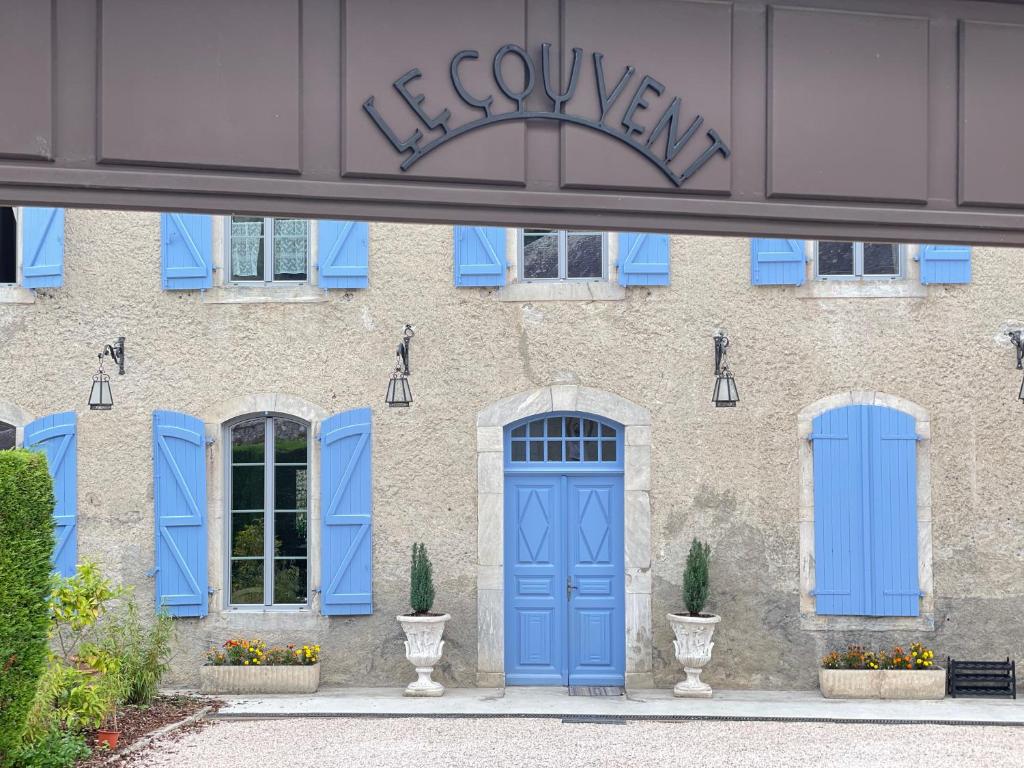 un edificio con puertas y ventanas azules en Maison d'hôtes Le Couvent, en Bagnères-de-Bigorre