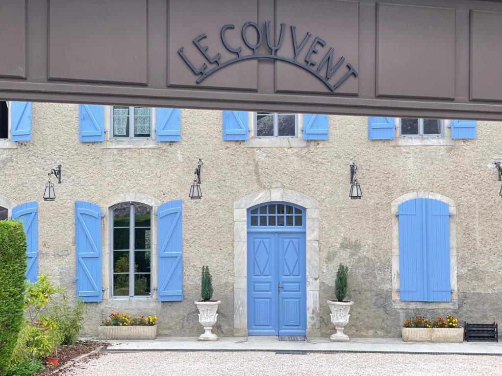 a building with blue doors and windows at Maison d'hôtes Le Couvent in Bagnères-de-Bigorre