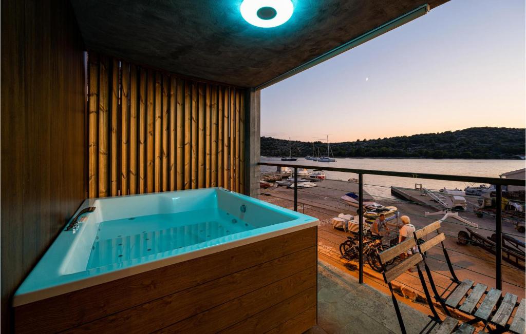 a hot tub on a balcony with a view of a boat at Cozy Home In Kaprije With Kitchen in Kaprije