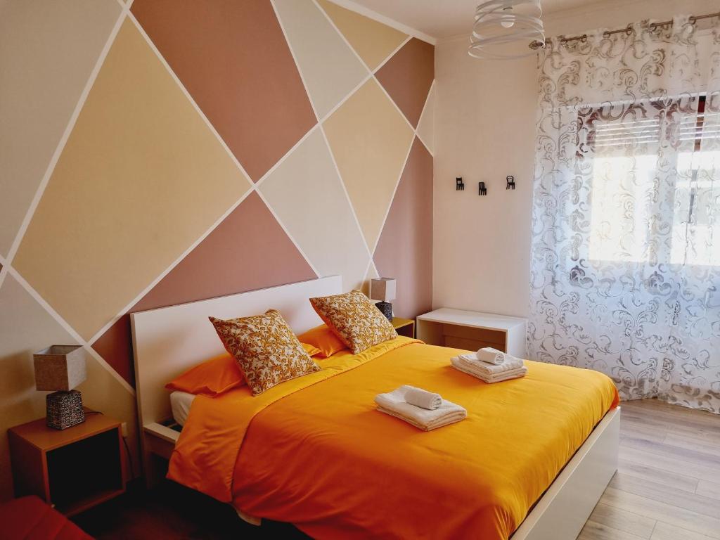 a bedroom with a large bed with orange sheets at Enne's Apartments in the heart of Palermo in Palermo