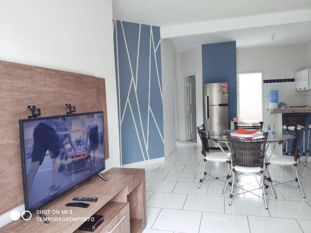 a living room with a television and a table with chairs at Apartamento completo com 3 quartos in Porto Seguro