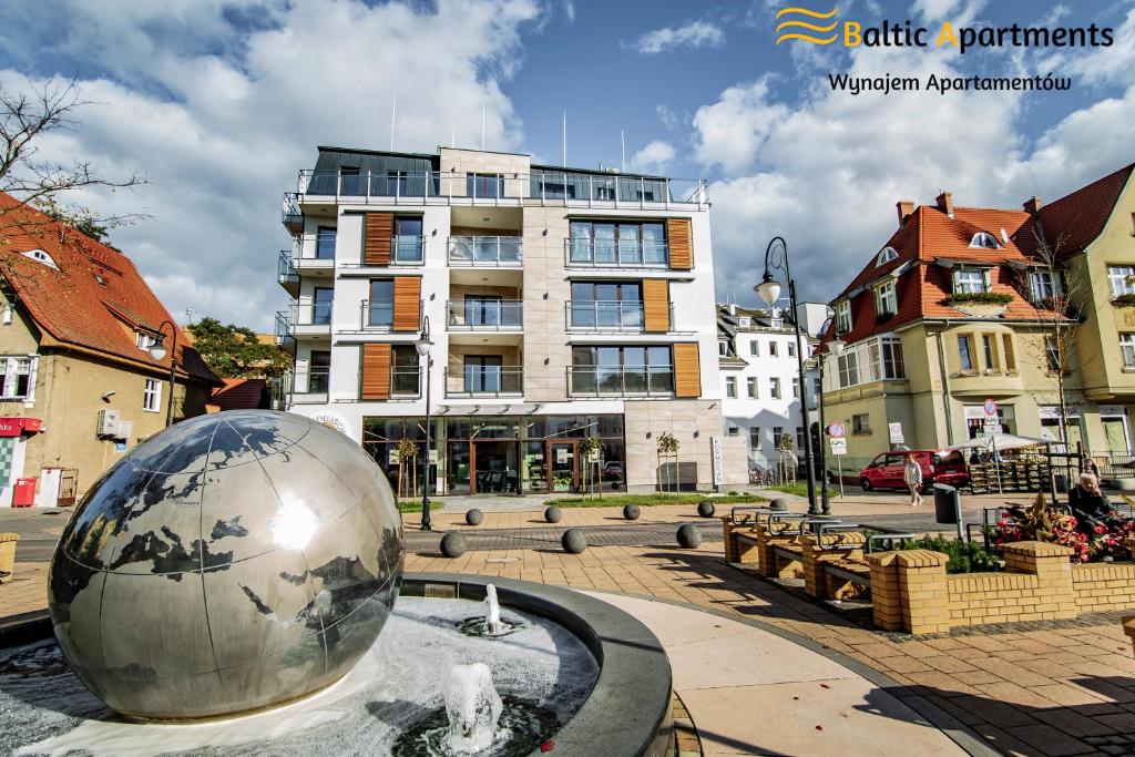 a large silver ball in front of a building at Baltic Apartments - Kormoran in Świnoujście