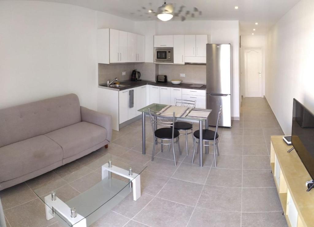 a kitchen and living room with a couch and a table at Modern 1 bed Apartment Cristianos in Arona